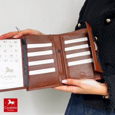 Carteira de couro castanha aberta mostrando compartimentos para cartões com etiquetas HANDMADE IN PORTUGAL.