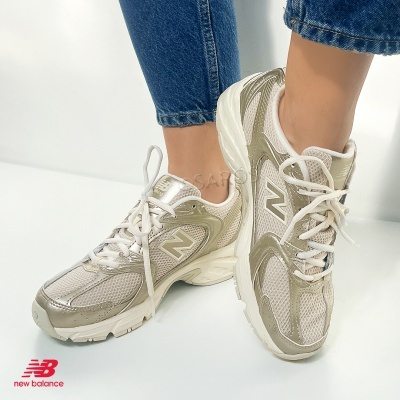 Ténis New Balance creme e bege com logótipo N usados com jeans
