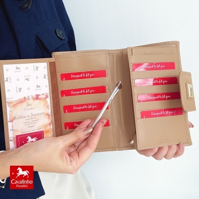 Carteira bege aberta em couro com cartões vermelhos 'Designed to fit you' e selo com gravura de cavalo