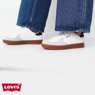 Ténis brancos LEVI'S com sola castanha e calças de ganga azuis