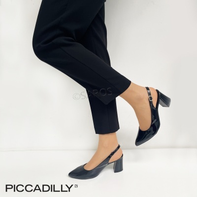 Sapatos de salto médio em verniz preto com tiras traseiras usados por pessoa com calças pretas