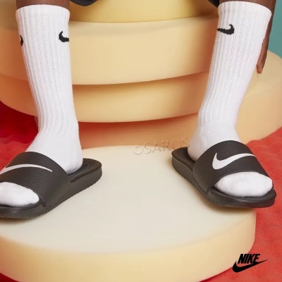 Meias brancas e chinelos pretos com logos Nike em fundo colorido.