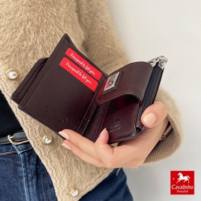 Carteira castanha de couro com fecho metálico e texto em etiquetas vermelhas
