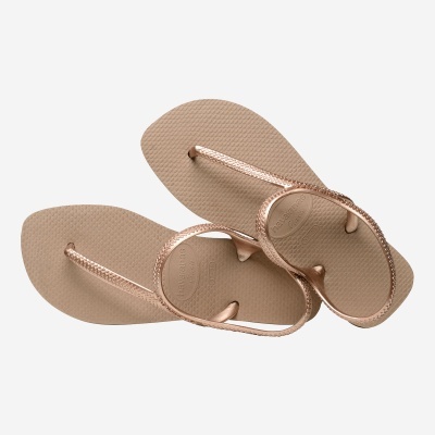 Chinelos Havaianas bege com tiras douradas rosa e texto havaianas flash