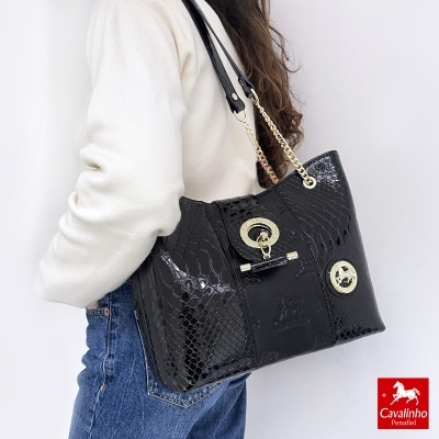 Mala preta de padrão tipo pele de cobra com detalhes dourados e alças de ombro