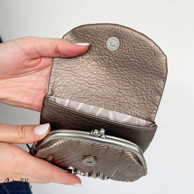 Carteira pequena castanha em pele sintética com fecho metálico e interior cinza com padrão