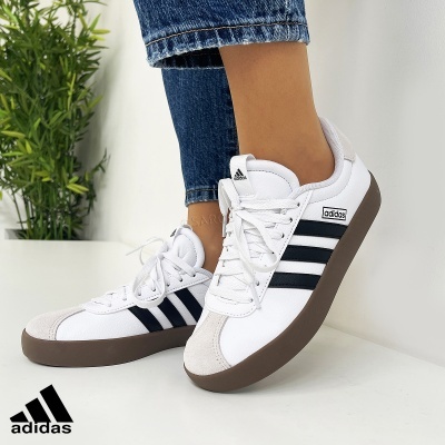 Ténis Adidas brancos com riscas pretas e sola castanha