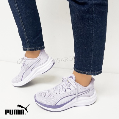 Ténis Puma lilás claro com detalhes roxos e sola branca usados com calças de ganga escuras