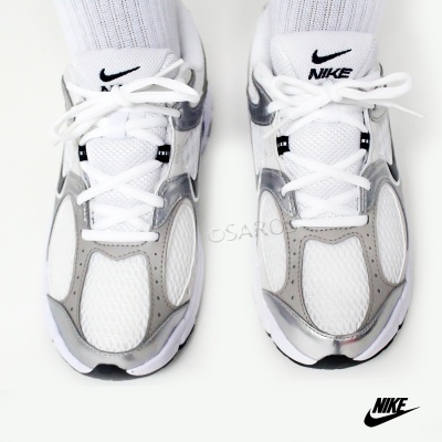 Ténis Nike brancos e cinza prateados com tecido de malha e couro sintético.