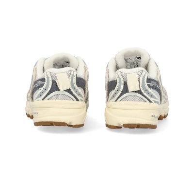 Calçado desportivo New Balance modelo 530 visto de trás, cinza e bege, com sola castanha