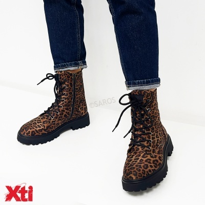 Botas animal print com atacadores e sola grossa preta usadas com jeans azul escuro