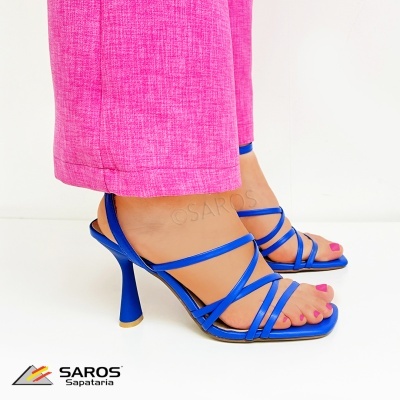 Sandálias de salto alto azuis com tiras finas e calças cor-de-rosa