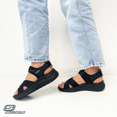 Sandálias negras Skechers com calças de ganga claras