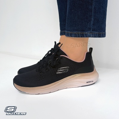 ténis desportivos pretos Skechers com sola bege e logo metálico