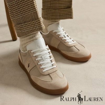 Ténis Ralph Lauren bege e branco com logo de cavaleiro, usados com meias brancas e calças xadrez castanhas.