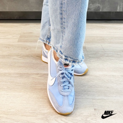 Ténis Nike azul claro com sola castanha usados com calças de ganga claras
