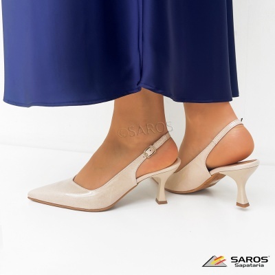 Sapatos de salto alto bege com tira ajustável usados com saia azul escura.