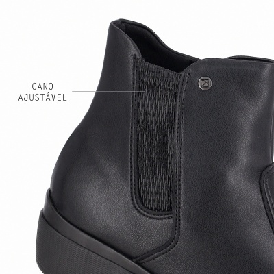 Bota preta de cano curto com detalhe de malha elástica e emblema metálico.