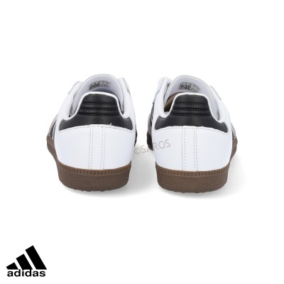 Ténis Adidas brancos com detalhes pretos e sola castanha vistos de trás