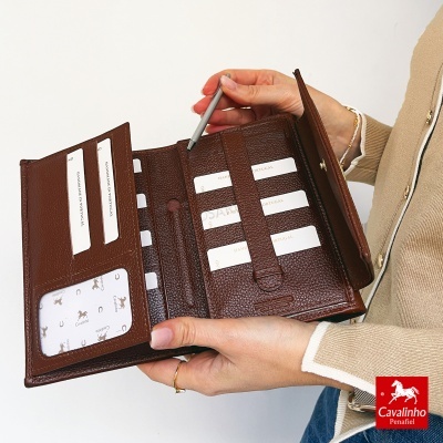 Carteira feminina em pele castanha com múltiplos compartimentos para cartões e um espaço para caneta