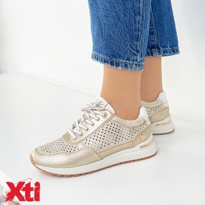 Ténis femininos dourados perfurados com sola branca e detalhes dourados