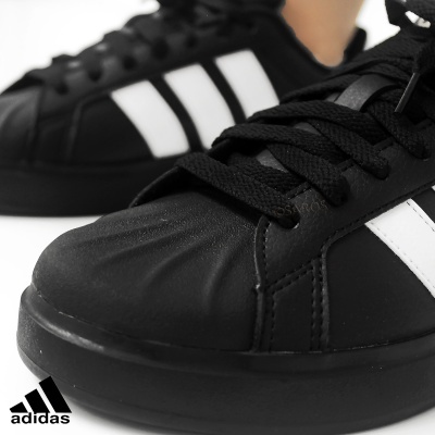 Ténis Adidas pretos com riscas brancas e atacadores pretos