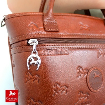 Mala castanha de couro com padrão de cavalos em relevo e fecho metálico com pendente circular