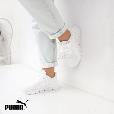 Ténis Puma brancos com sola grossa usados com calças de ganga claras