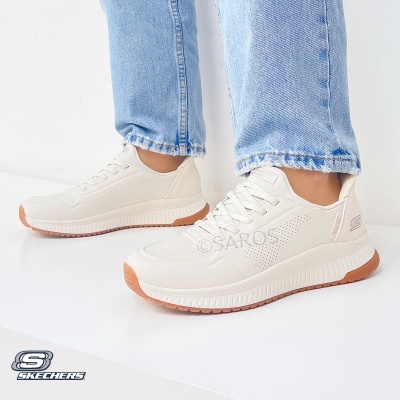 Ténis branco Skechers com sola castanha e calças de ganga azul clara
