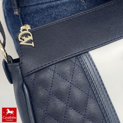 Mala azul escura em couro com padrão quadrado e fecho dourado com letras N e V