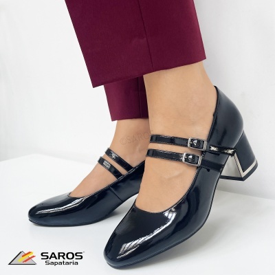 Sapatos pretos em verniz com salto alto quadrado e fivelas duplas.