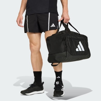 Mala desportiva preta com logotipo branco Adidas e calções pretos com riscas brancas e logotipo Adidas.
