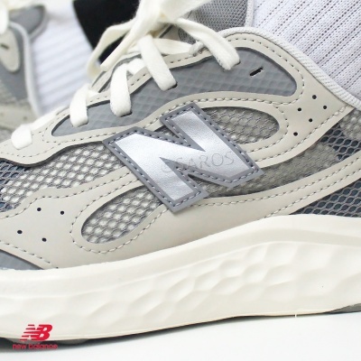 Ténis New Balance cinza e branco com logo prateado e sola branca