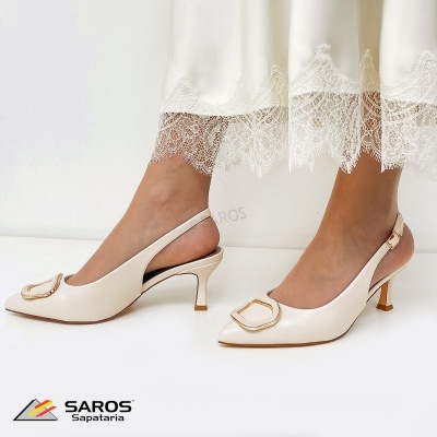 Sapatos de salto médio bege com fivela dourada e vestido branco com renda na barra