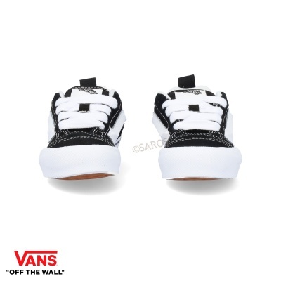 Ténis Vans pretos e brancos vistos de frente com cadarços brancos