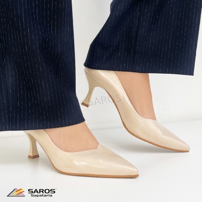 Sapatos de salto médio bege brilhante com bico fino e calças azuis escuras às riscas