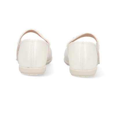 Sapatos infantis brancos com fivela ajustável vistos de trás