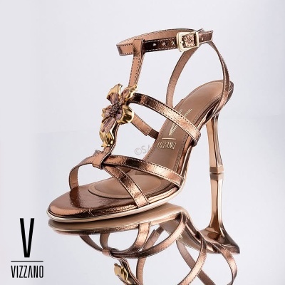 Sandália de salto alto bronze com flor dourada e tiras finas em fundo branco