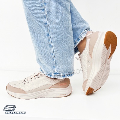 Ténis Skechers bege claro com sola branca e castanha, padrão matelassé e texto na lateral