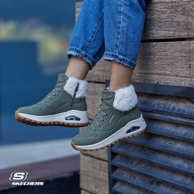 Tênis verdes Skechers com pelo branco usados com jeans azuis