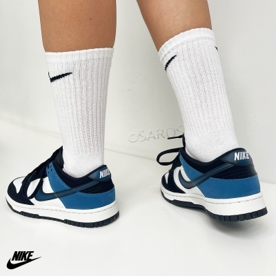 Sapatilhas Nike azul, branco e preto com meias brancas numa superfície branca