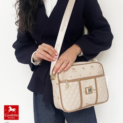 Mala de ombro bege Cavalinho com motivos de cavalos e ferraduras, alça ajustável com texto, pessoa a usar blazer preto