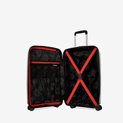 Mala de viagem rígida aberta com interior preto e cintas vermelhas