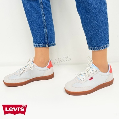 Sapatilhas Levi's brancas com detalhes vermelhos e sola castanha, com jeans azuis