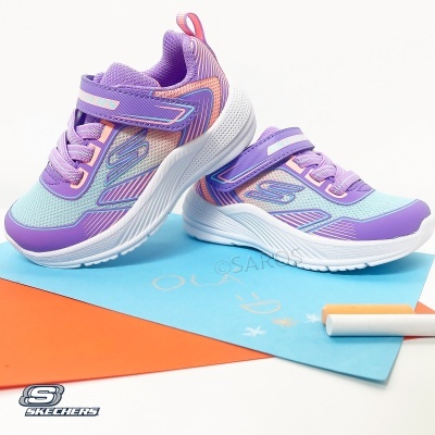 Ténis infantis Skechers lilás e azul claro com fecho em velcro sobre folhas de papel coloridas