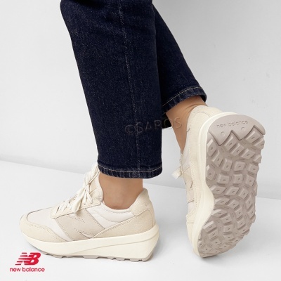 Ténis New Balance creme com sola de plataforma e padrão antiderrapante