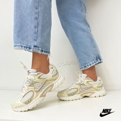 Tênis desportivos Nike bege e branco com malha ventilada e detalhes em pele sintética