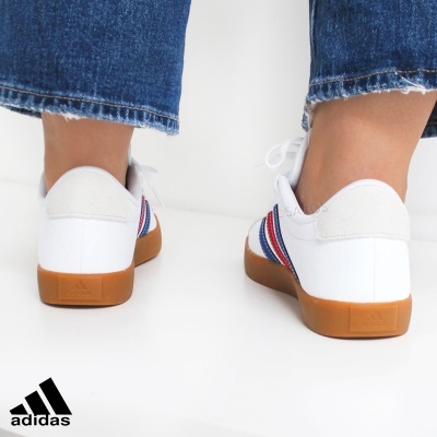 Ténis Adidas brancos com sola castanha vistos por trás