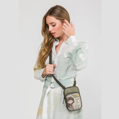 Mulher de vestido suave com mala pequena verde à tiracolo com ilustração e texto