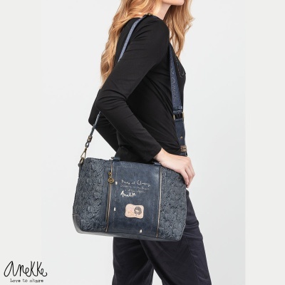 Mala azul escura matelassê com estampa Anekke e modelo vestindo roupa preta